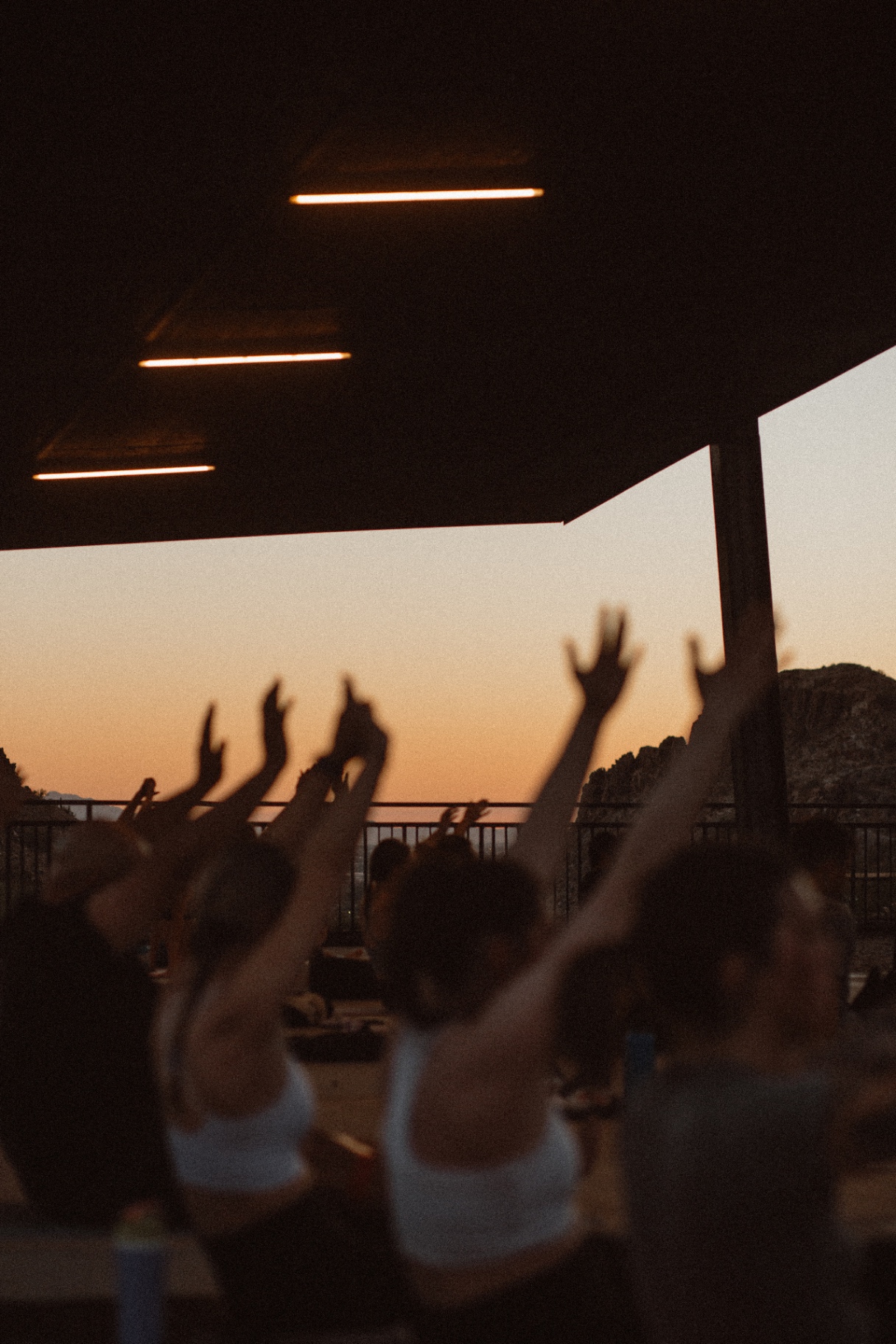 Hands raised at sunset